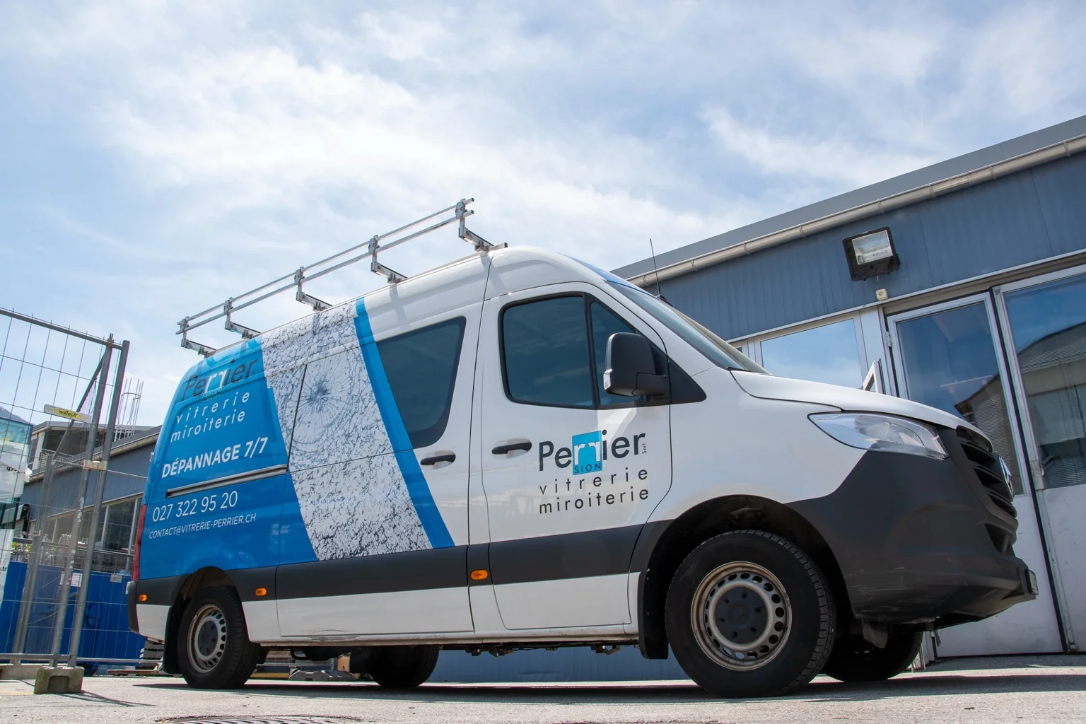 Véhicule utilitaire Perrier Vitrerie stationné devant les ateliers de l’entreprise, utilisé pour les interventions de dépannage vitrage et miroiterie en Valais.